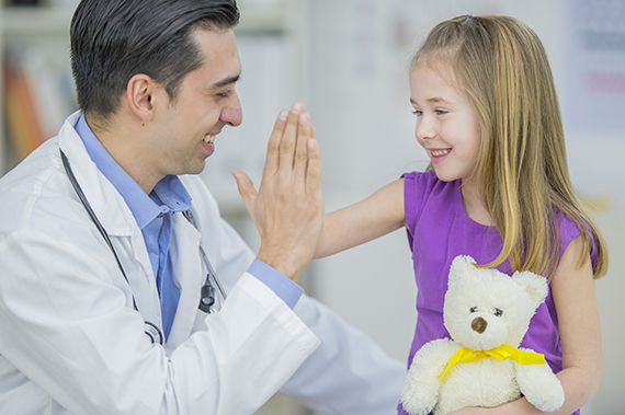 A young patient high-fives a pediatrician