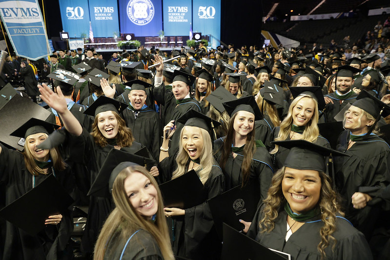 Graduates in regalia smile for the camera during 2024 Commencement