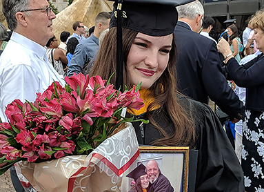 Ciara Jenkins holds a photo of her and her father following commencement