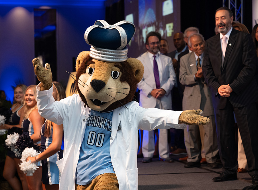 ODU's mascot's, Big Blue, dons a medical white coat to commemorate the EVMS integration into ODU.
