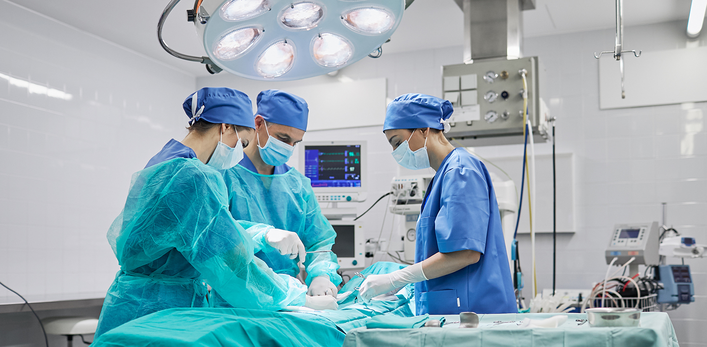 Three medical experts performing surgery