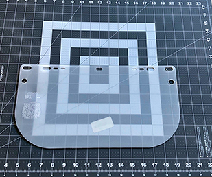 Align plastic shield in middle of mat; the opaque plastic is on the inside of the shield – you can tell by the engraving on the side.